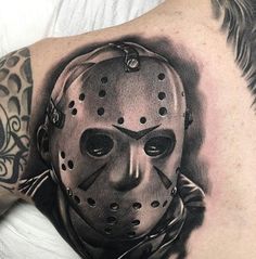 a man with a tattoo on his shoulder has a hockey mask tattooed on his arm