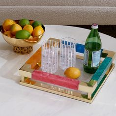 a tray with glasses, lemons and limes sitting on top of a table