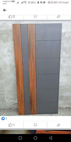 an image of a wooden door with grey and brown panels on the bottom, in front of a white wall