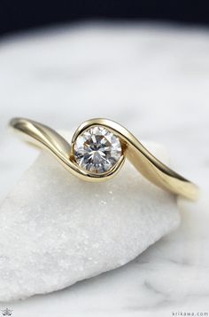 This affordable custom engagement ring gently flows around the diamond like waves on a beach.  What colors do you like?  How about Rose Gold with a Champagne Diamond? Carved Gold Engagement Ring, Elegant Simple Engagement Rings, Wave Engagement Ring, Elegant Engagement Rings Gold, Modern Ring Settings, Flat Engagement Ring, Flat Engagement Rings, Wave Wedding Band, Tension Set Engagement Rings