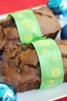 chocolate muffins wrapped in green paper on a plate with blue and red ornaments