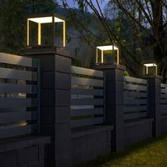 three lights on top of a fence at night