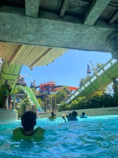 people are swimming in the water at an amusement park with slides and waterslides