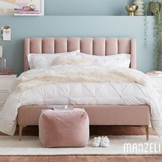 a bedroom with blue walls and white bedding, pink footstools and a beige upholstered bed