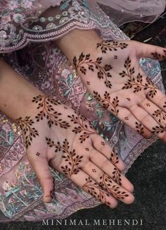 two hands with hendi designs on them, one is holding the other's hand