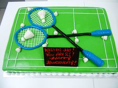 a birthday cake with tennis rackets and a happy birthday sign on it's side