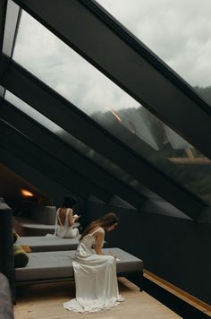 a woman sitting on top of a couch next to a window