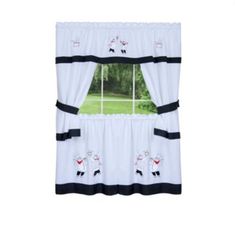 a window curtain with sheeps on it in front of a green field and trees