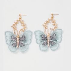 two pairs of butterfly earrings with gold chains and crystal stones on the bottom, one is light blue