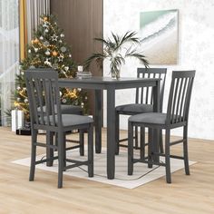 a dining room table and chairs with a christmas tree in the corner next to it