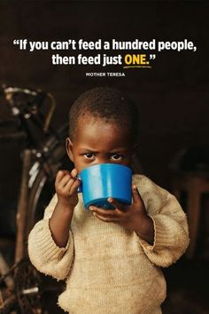 a little boy holding a blue cup in front of his face