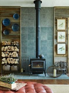 a living room filled with furniture and a wood burning stove in the middle of it