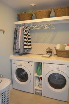 a washer and dryer in a laundry room with baskets on the shelves above them