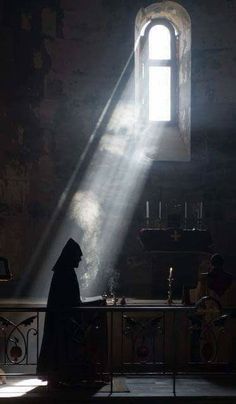 a person standing in front of a table with a light coming from it's window