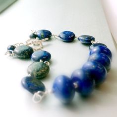 This lapis lazuli bracelet handcrafted by Jewelry By Carmal is made of navy blue lapis lazuli rondelle and disk gemstones, sterling silver: crown charm, toggle and findings. This bracelet measures up to 7 3/4 inches in length. View more beaded bracelets: http://www.etsy.com/shop/jewelrybycarmal?section_id=8002918 The ancient Romans used lapis as an aphrodisiac. Lapis lazuli is said to help stimulate emotional, mental, and physical purity and clarity. The ancient Egyptians used lapis for protecti Blue Lapis Lazuli Gemstone Beaded Bracelet, Blue Gemstone Bracelets For Everyday Wear, Blue Lapis Lazuli Beaded Bracelets With Polished Beads, Artisan Blue Gemstone Beaded Bracelets, Blue Sodalite Round Beaded Jewelry, Blue Sodalite Jewelry With Natural Stones, Blue Sodalite Jewelry, Blue Lapis Lazuli Bracelets With Polished Beads, Blue Gemstone Beads Bracelet For Everyday