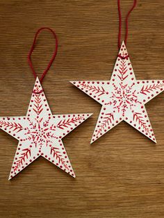 two red and white stars hanging on a wooden table