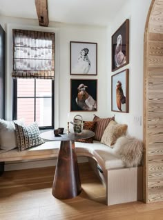 a living room filled with lots of furniture and pictures on the wall next to a window