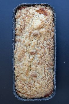 a pan filled with food sitting on top of a blue countertop next to a knife