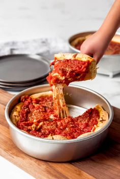 the chicago deep dish pizza is being lifted with a spatula