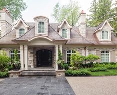 the front entrance to a large house with lots of windows