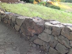 a stone wall in the middle of a field