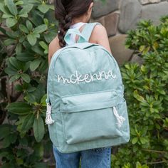 a girl wearing a backpack with the word'ndelena written on it