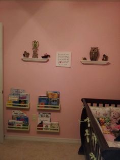 a baby's room with pink walls and teddy bears on the shelves above the crib