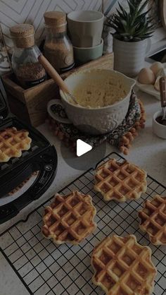 four waffles cooling on a rack next to a bowl of oatmeal