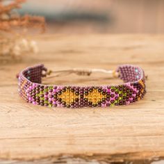 Guatemalan artisans from the Hands Of Atitlan Association see in the region's splendid landscapes the perfect muse for a series of unique accessories. Made from glass beads, this wristband bracelet displays a geometric pattern inspired by Atitlan's nature, featuring a palette of purple and golden hues for a majestic look. Traditional Multicolor Beaded Wristband, Multicolor 8mm Beaded Wristband, Sea Glass Crafts Jewellery, Luxury Multicolor Hand-strung Beaded Bracelets, Bohemian Multicolor Beaded Wristband, Bohemian Multi-strand Purple Beaded Bracelets, Wristband Bracelet, Buy Bead, Bracelet Display