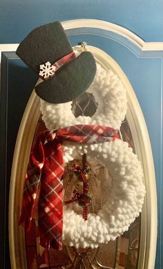 a snowman wreath is hanging on the front door