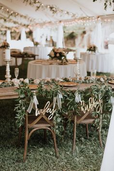 the chairs are decorated with greenery and wooden signs that read happily married on them