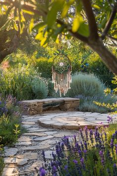 an outdoor area with stone walkways, plants and a dream catcher hanging from the tree