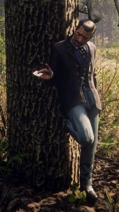 a man leaning against a tree in the woods