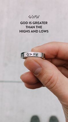 someone is holding their wedding ring with the words god is greater than the highs and lows