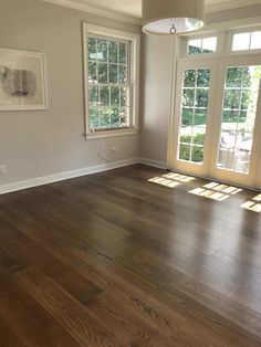 an empty living room with hard wood floors