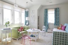 a living room filled with furniture next to a window covered in blue and green curtains