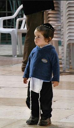 a little boy standing on top of a tiled floor