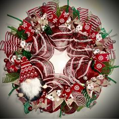 a red and white christmas wreath with ornaments