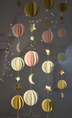 a mobile with paper lanterns and stars hanging from it's sides in a room