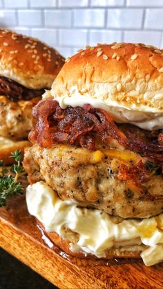 two burgers with meat and cheese on a wooden board