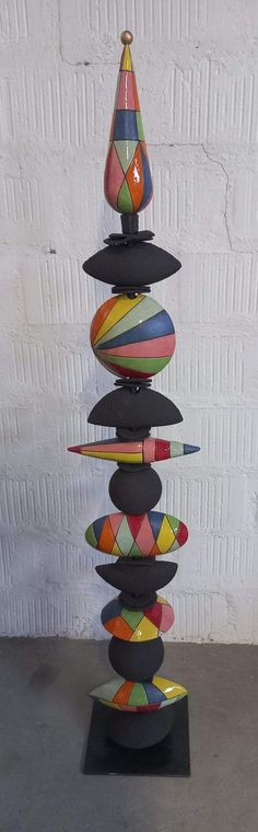 a stack of colorful objects sitting on top of a black stand