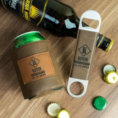 a bottle opener and leather case sitting on top of a wooden table next to bottles