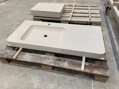 a sink sitting on top of pallets in a warehouse filled with cement blocks and wooden pallets