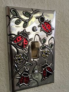 a decorative light switch cover with ladybugs on it