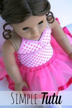 the doll is wearing a pink and white dress with polka dots on it's chest