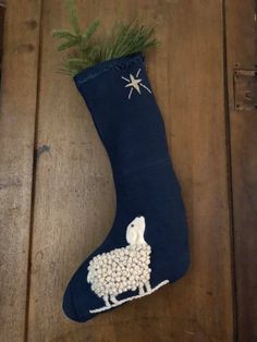 a christmas stocking with a sheep on it sitting on top of a wooden floor