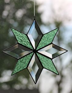 a stained glass star ornament hanging from a string