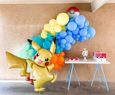 a pokemon balloon wall with balloons attached to it and a pikachu balloon in the air