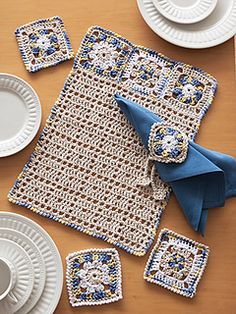 crocheted placemats, napkins and plates on a wooden table top