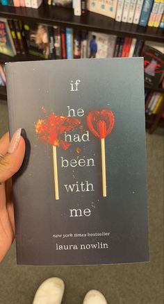 the book if he had been with me is being held up by someone's hand